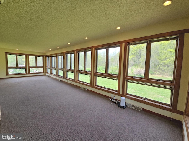 unfurnished sunroom with recessed lighting, a textured ceiling, and carpet floors