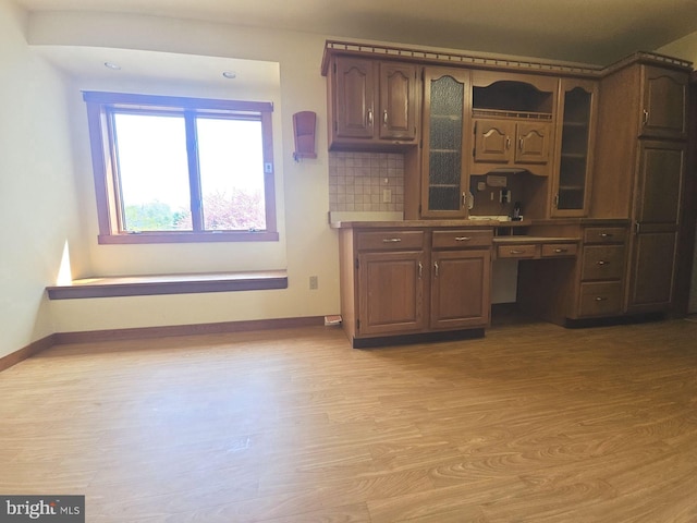 unfurnished office with baseboards and light wood-style floors