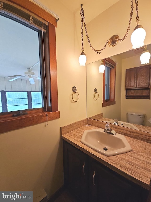 bathroom with toilet, ceiling fan, and vanity