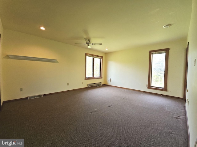 empty room featuring recessed lighting, visible vents, dark carpet, and a healthy amount of sunlight