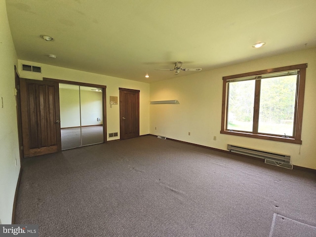 interior space with a ceiling fan, visible vents, dark colored carpet, and a baseboard radiator