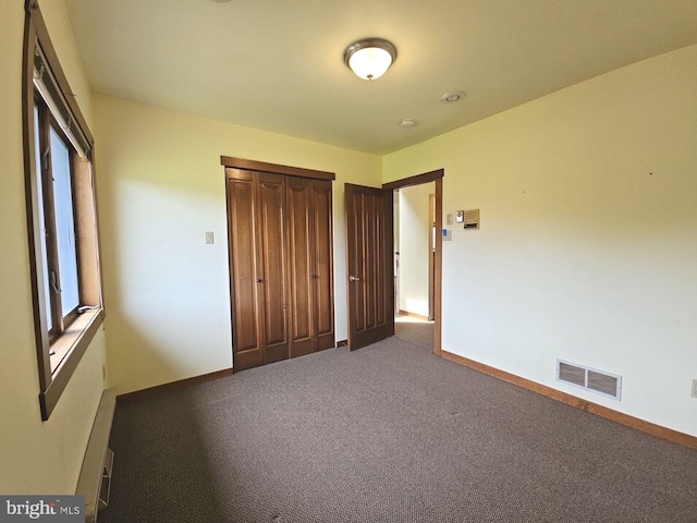 unfurnished bedroom featuring baseboards, visible vents, a closet, and carpet