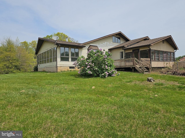 rear view of property with a sunroom and a lawn