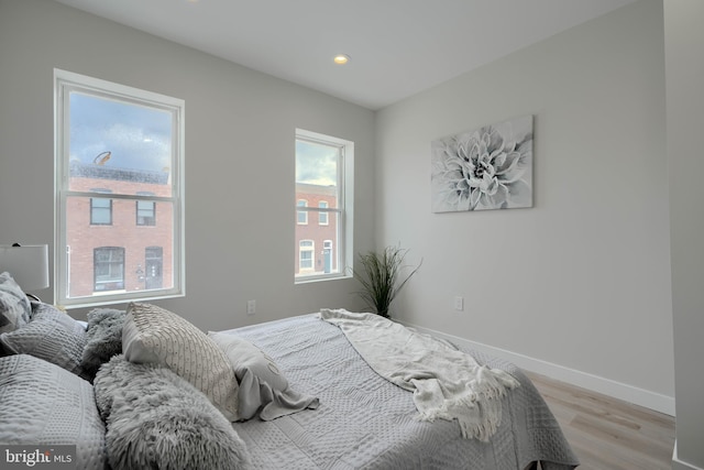 bedroom with baseboards, recessed lighting, and light wood finished floors