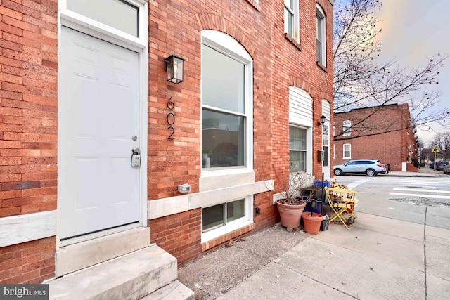 entrance to property featuring brick siding