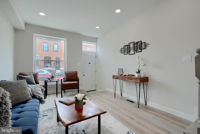 living area with baseboards, visible vents, light wood-style floors, and recessed lighting