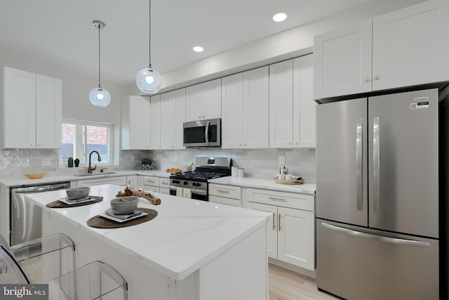 kitchen featuring white cabinetry, stainless steel appliances, decorative backsplash, and a sink