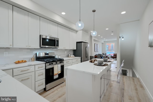kitchen with a center island, stainless steel appliances, backsplash, and white cabinets