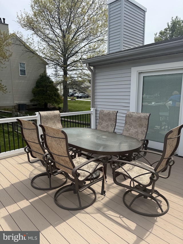 wooden deck with central AC unit and outdoor dining area