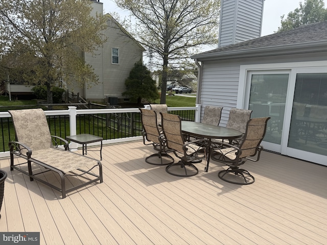 deck featuring outdoor dining area and a yard