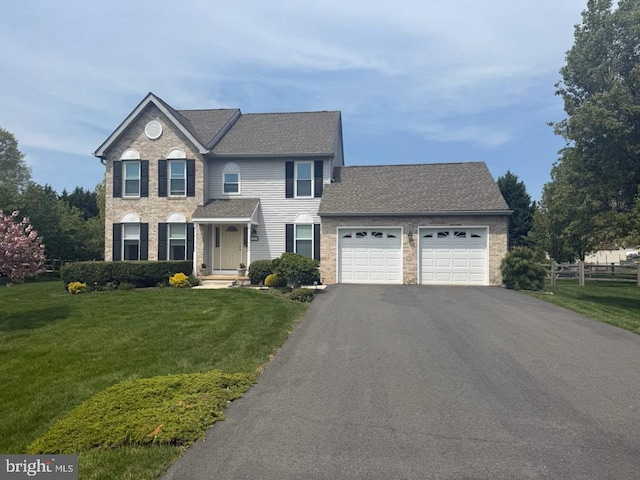 view of front of property with a front yard, roof with shingles, a garage, and aphalt driveway
