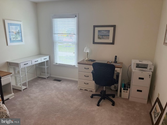 home office featuring light colored carpet, visible vents, and baseboards