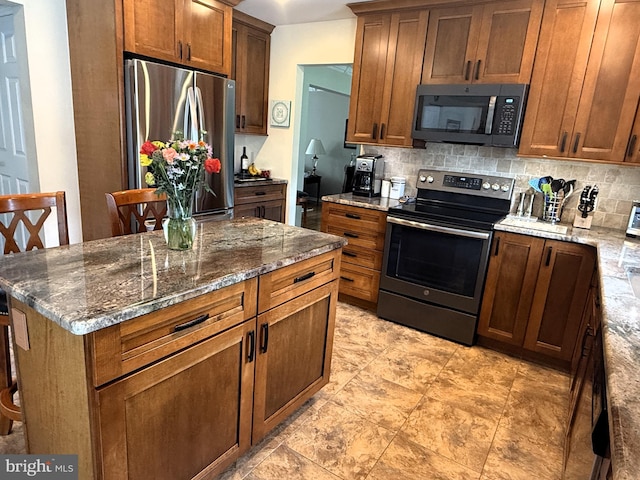 kitchen with appliances with stainless steel finishes, brown cabinets, tasteful backsplash, and stone countertops