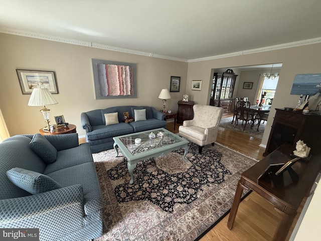 living area featuring crown molding, wood finished floors, and baseboards