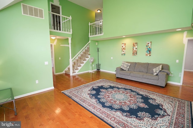 30085 Haymarket Ct, Salisbury, MD 21804 - living room featuring a towering ceiling, stairs, baseboards, wood finished floors, and recessed lighting