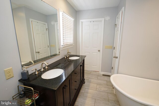 30085 Haymarket Ct, Salisbury, MD 21804 - bathroom with a freestanding tub, double vanity, and baseboards