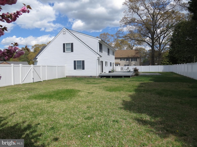 rear view of property with a yard, a wooden deck, and a fenced backyard
