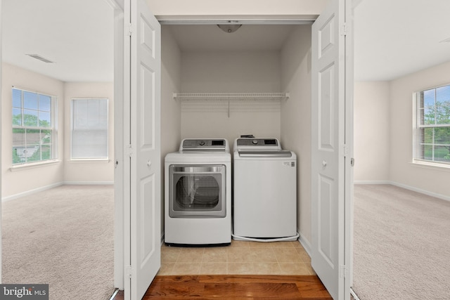 washroom with visible vents, washing machine and clothes dryer, carpet flooring, and laundry area