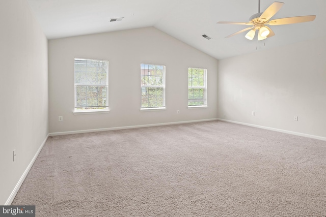 carpeted spare room with baseboards, visible vents, ceiling fan, and vaulted ceiling