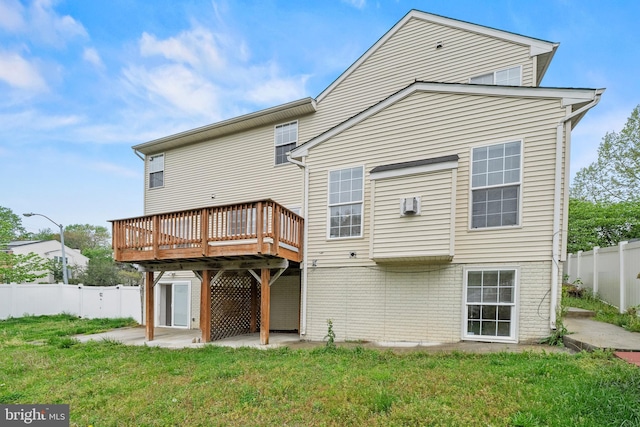 back of property featuring a lawn, a wooden deck, a wall mounted AC, and fence