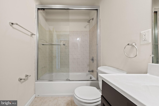 bathroom with baseboards, enclosed tub / shower combo, toilet, tile patterned floors, and vanity