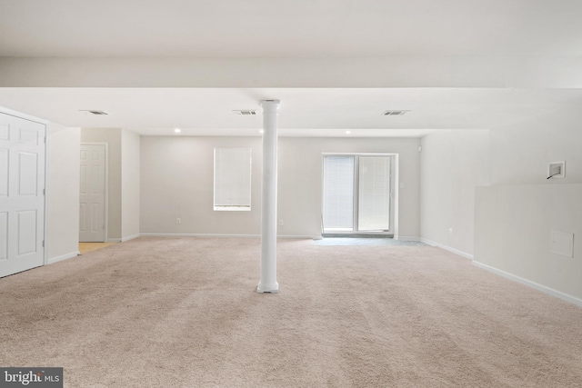 basement featuring visible vents, light carpet, and baseboards