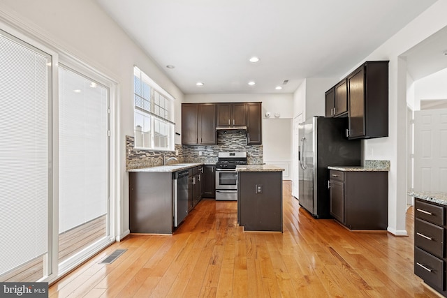 kitchen featuring tasteful backsplash, visible vents, light wood-style floors, and appliances with stainless steel finishes