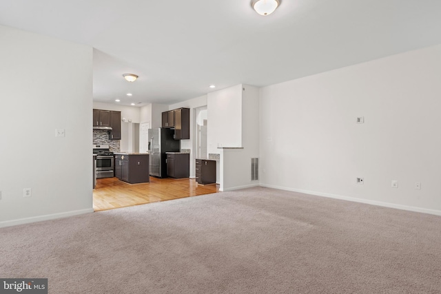 unfurnished living room with baseboards, recessed lighting, visible vents, and light carpet