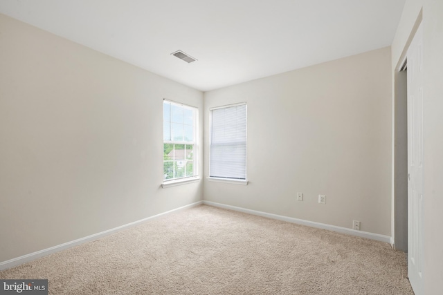 unfurnished room featuring visible vents, carpet, and baseboards