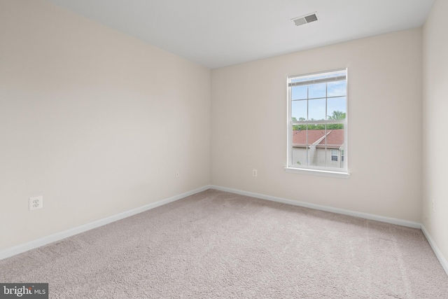 carpeted spare room with visible vents and baseboards