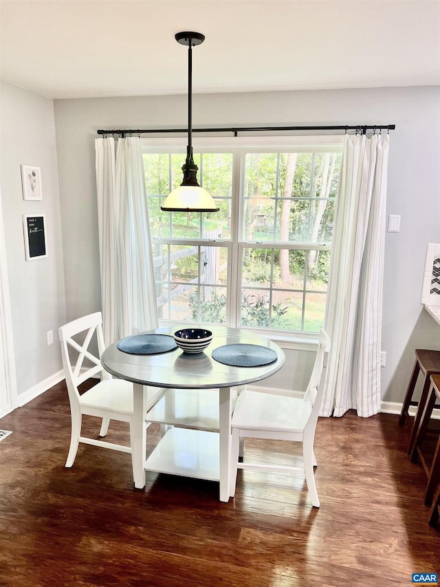 dining space with baseboards and wood finished floors