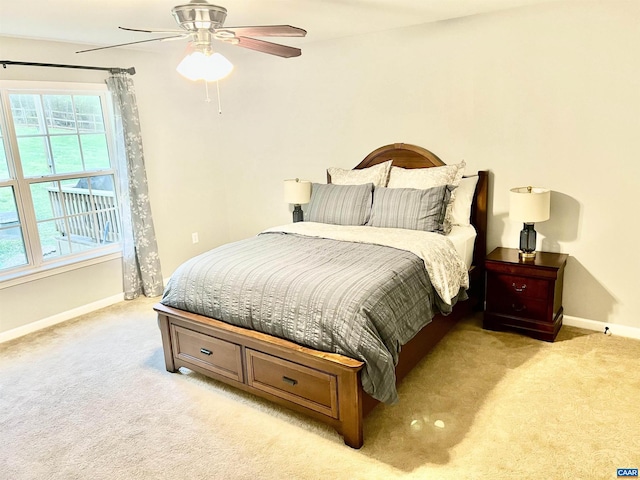 bedroom with baseboards, a ceiling fan, and light carpet