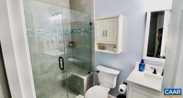 bathroom featuring a stall shower, toilet, and vanity