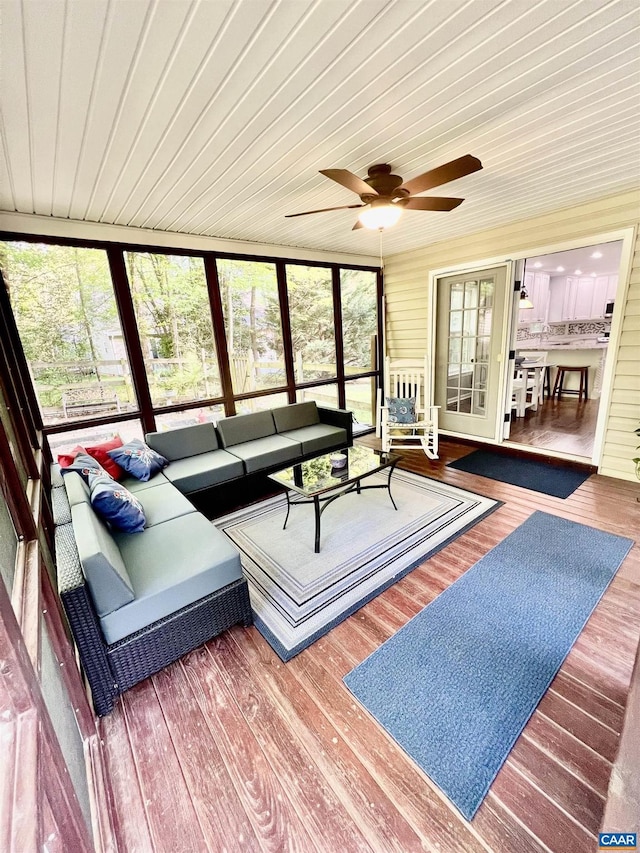 living area featuring wood ceiling, wood finished floors, and ceiling fan