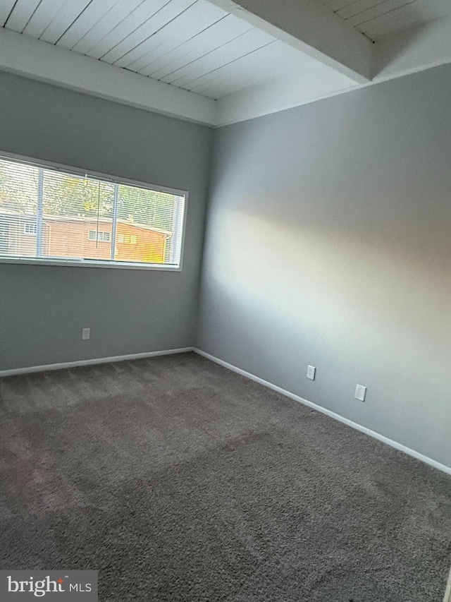 carpeted empty room with wooden ceiling, beam ceiling, and baseboards