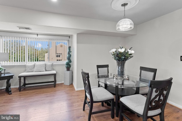 8101 Greenspring Way Unit 8101-E, Owings Mills, MD 21117 - dining room with visible vents, a notable chandelier, wood finished floors, and baseboards