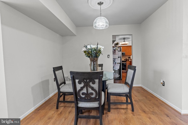 8101 Greenspring Way Unit 8101-E, Owings Mills, MD 21117 - dining area featuring a chandelier, baseboards, and light wood-type flooring