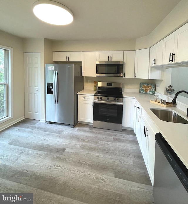 20002 Apperson Pl, Germantown, MD 20876 - kitchen featuring a sink, white cabinets, stainless steel appliances, and light wood-type flooring
