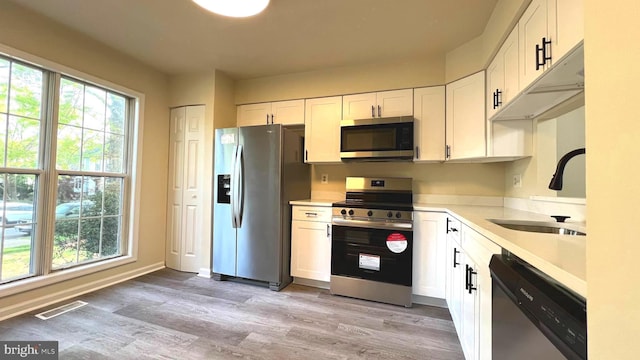 20002 Apperson Pl, Germantown, MD 20876 - kitchen featuring visible vents, plenty of natural light, a sink, light wood finished floors, and appliances with stainless steel finishes