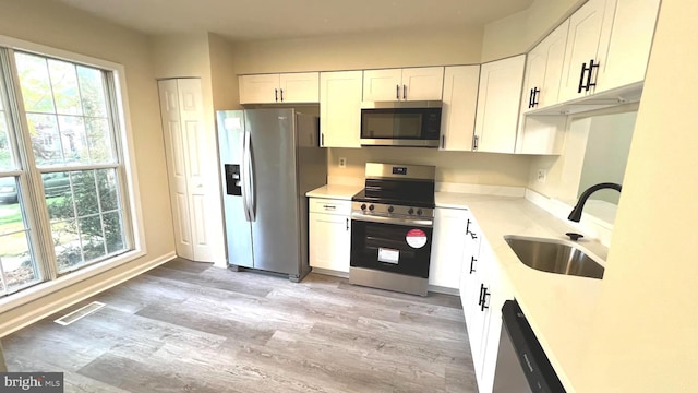 20002 Apperson Pl, Germantown, MD 20876 - kitchen featuring visible vents, light wood-type flooring, white cabinets, a sink, and stainless steel appliances