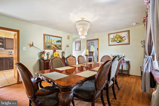 dining room featuring light wood-type flooring and a chandelier