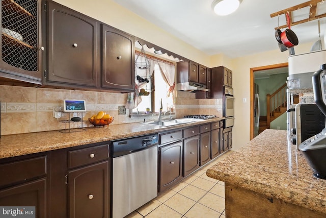 kitchen featuring decorative backsplash, dark brown cabinets, a sink, a warming drawer, and stainless steel appliances