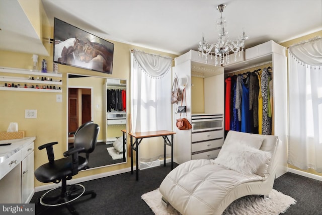 interior space with baseboards, dark colored carpet, and a notable chandelier