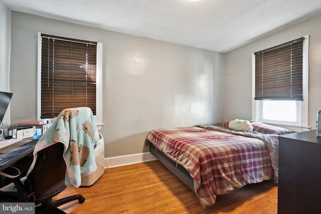 bedroom with baseboards and wood finished floors
