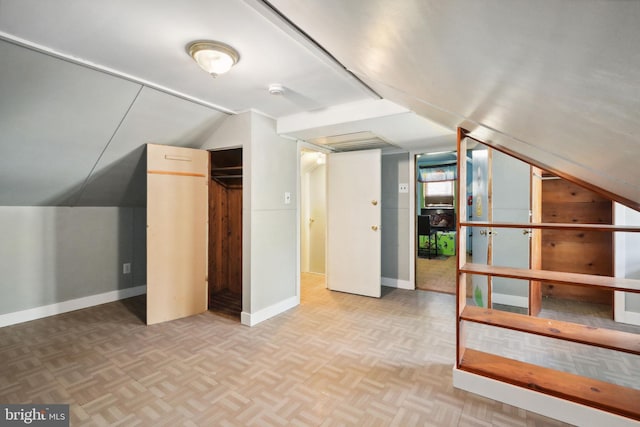 additional living space featuring baseboards and lofted ceiling