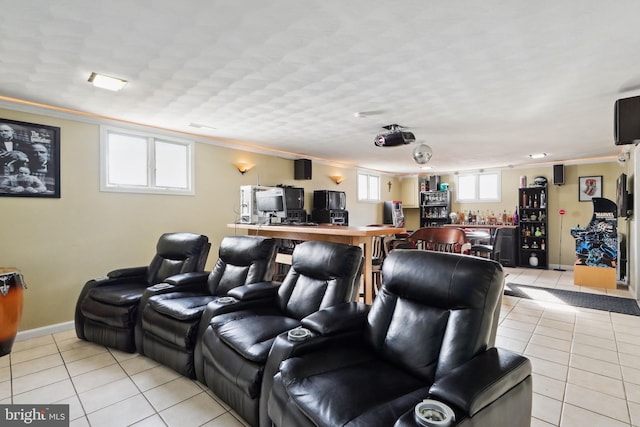 cinema room with crown molding, baseboards, a dry bar, and light tile patterned floors