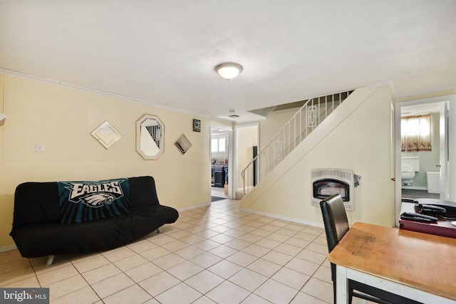 living room with heating unit, light tile patterned floors, and stairway