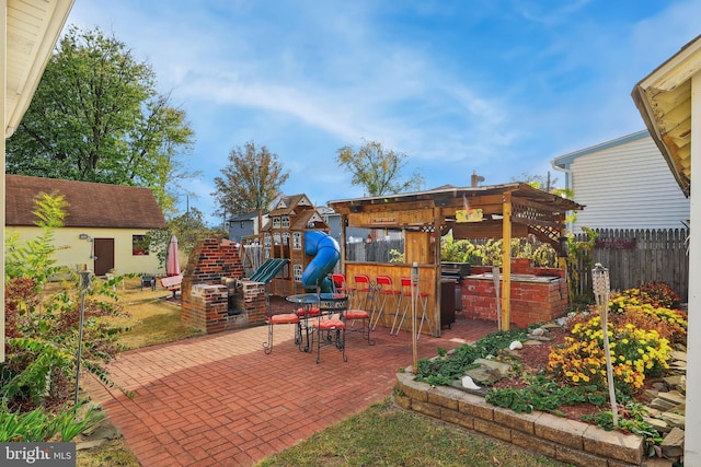 view of patio with fence and a playground