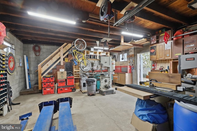 interior space featuring concrete block wall, stairs, and a workshop area