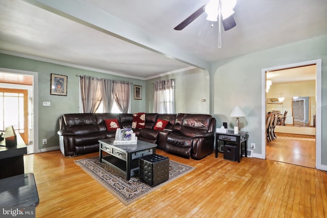 living area featuring crown molding, a ceiling fan, baseboards, and hardwood / wood-style flooring